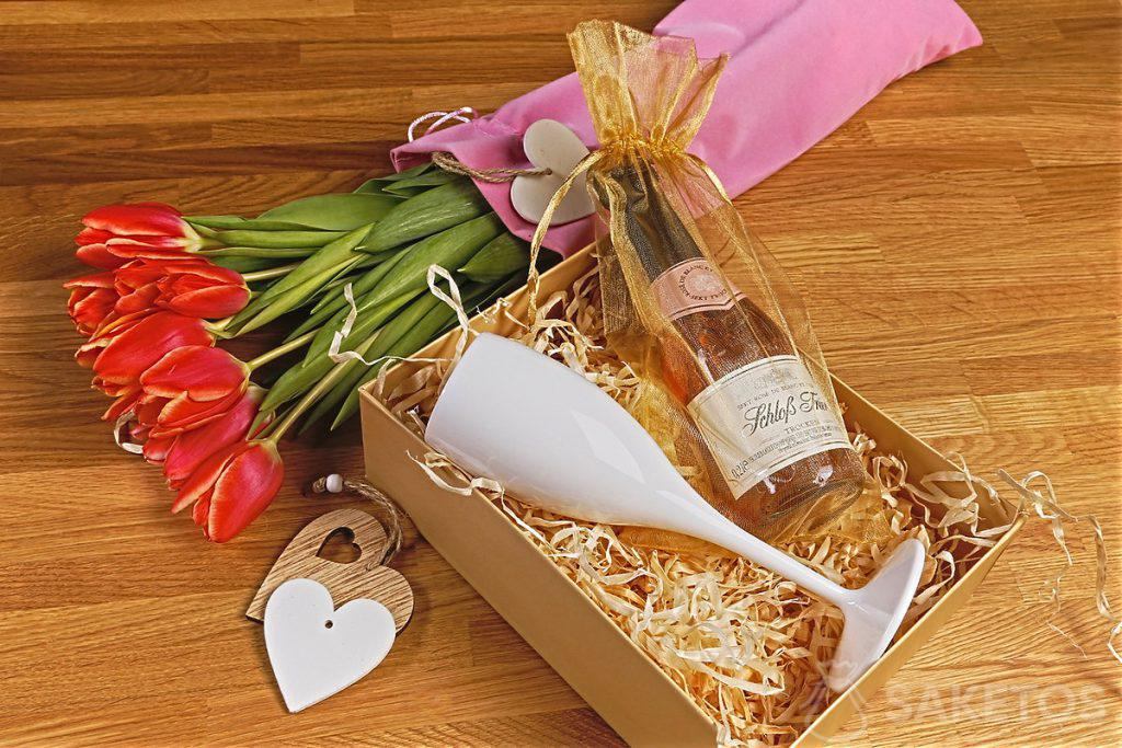 Bloemen in een fluwelen zakje en een geschenkdoosje met een glas voor Vrouwendag