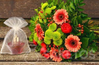 Een cadeauset voor een vrouw - een boeket bloemen en parfum in een organza zakje