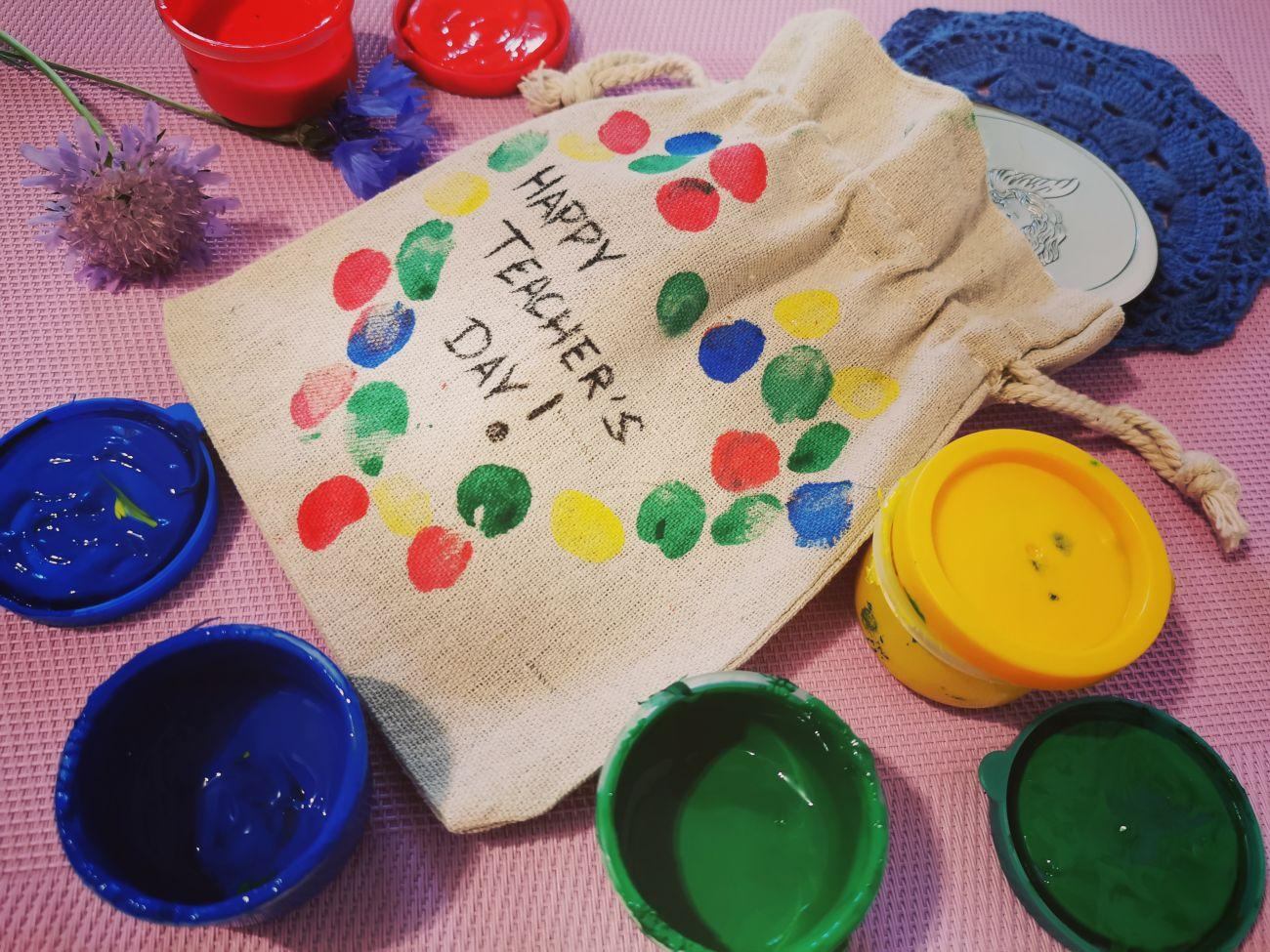 Een cadeau voor een leraar in een zak versierd met de vingerafdrukken van zijn leerlingen