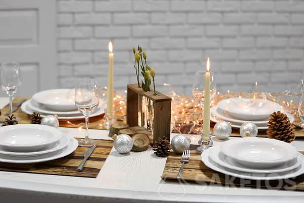 Kersttafel met wit tafelkleed - wit tafelkleed en houten accessoires