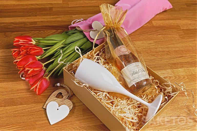 Bloemen in een elegant fluwelen zakje en geschenkset met glas - het perfecte cadeau voor Vrouwendag