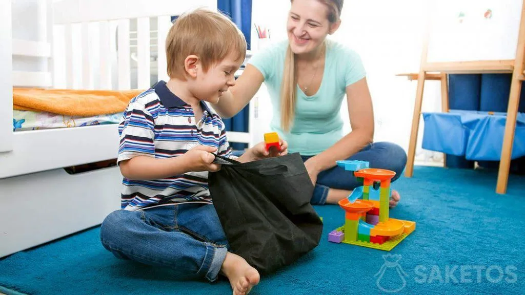 LEGO- en houten blokjes, hoe ze te scheiden en op te bergen? 2 1.Een jongen neemt blokjes uit een stoffen zakje
